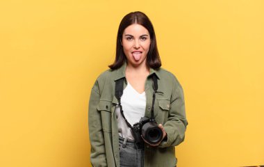 Genç ve güzel bir kadın, tiksinmiş ve rahatsız olmuş hissediyor. Dilini dışarı çıkarıyor, iğrenç ve iğrenç bir şeyden hoşlanmıyor.