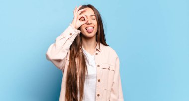 Genç, hoş, sıradan bir kadın mutlu bir şekilde gülümsüyor, şaka yapıyor ve gözetleme deliğinden bakıyor, sırları gözetliyor.