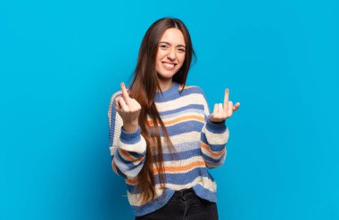 Genç, hoş, sıradan bir kadın. Kışkırtıcı, agresif ve müstehcen. İsyankar bir tavırla orta parmağını hareket ettiriyor.