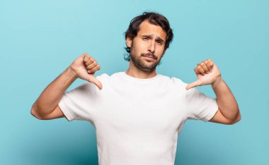 Genç, yakışıklı Hintli adam üzgün, hayal kırıklığına uğramış ya da kızgın görünüyor, anlaşmazlık içinde parmaklarını gösteriyor, hayal kırıklığına uğramış hissediyor.