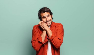 Genç, yakışıklı Hintli bir adam aşık ve yakışıklı görünüyor. Sevimli, sevimli ve mutlu. Romantik bir şekilde gülümsüyor.