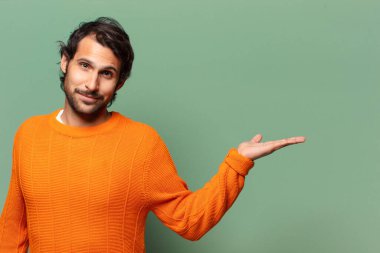 Genç, yakışıklı, etkileyici ve şaşırmış Hintli bir adam.