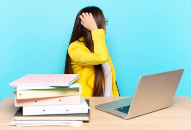 Genç güzel iş kadını düşünüyor ya da şüphe ediyor, kafasını kaşıyor, kafası karışık ve kafası karışık hissediyor, geriye ya da arkaya bakıyor.