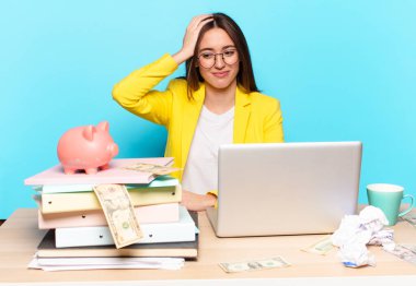 Masasında oturan iş kadını bir dizüstü bilgisayarla çalışıyor.