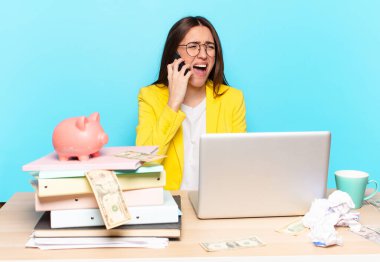 Masasında oturan iş kadını bir dizüstü bilgisayarla çalışıyor.