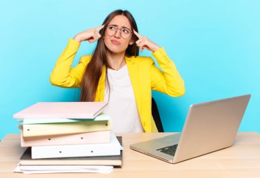 Genç ve güzel iş kadını konsantre olmuş ve bir fikir üzerinde kafa yoruyor, bir soruna ya da soruna bir çözüm hayal ediyor.