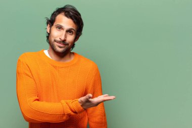 Genç, yakışıklı, etkileyici ve şaşırmış Hintli bir adam.