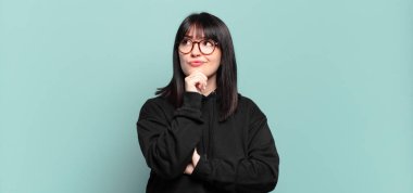 Artı boyut olarak güzel bir kadın. Düşünüyor, kuşkulu ve kafası karışık. Farklı seçenekleri var.