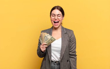 Genç ve güzel bir kadın agresif bir şekilde bağırıyor, kızgın, sinirli, öfkeli ya da sinirli görünüyor.