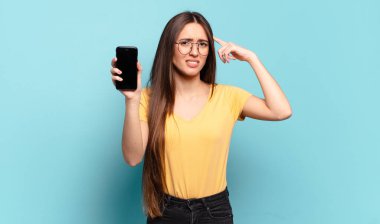 Genç, güzel bir kadın kafası karışık ve şaşkın hissediyor. Deli, deli ya da aklını kaçırmış olduğunu gösteriyor.