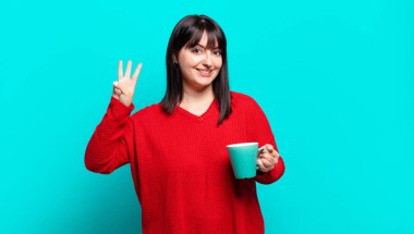 Artı güzel bir kadın gülümsüyor ve arkadaş canlısı görünüyor, üç ya da üç numarayı gösteriyor, eli önde, geriye doğru sayıyor.