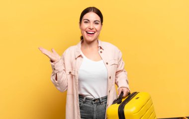 Genç, güzel bir kadın kendini mutlu, şaşırmış ve neşeli hissediyor. Pozitif bir tavırla gülümsüyor. Bir çözüm ya da fikir buluyor.