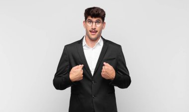 Genç yakışıklı adam mutlu, şaşkın ve gururlu, heyecanlı, şaşkın bakışlarıyla kendini işaret ediyor.