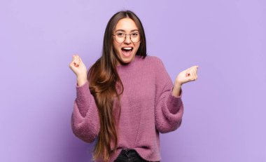 Genç, hoş, sıradan bir kadın mutlu, heyecanlı, şaşırmış ya da şok olmuş, gülümseyen ve hayrete düşmüş.