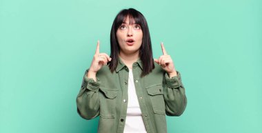 Artı boyut olarak güzel bir kadın hayranlık duyuyor ve ağzı açık. Şok olmuş ve şaşırmış bir şekilde yukarı bakıyor.