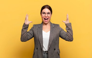 Genç ve güzel bir kadın öfkeli bir ifadeyle ya da yumruklarıyla başarıyı kutlarken agresif bir şekilde bağırıyor.