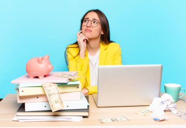 Masasında oturan iş kadını bir dizüstü bilgisayarla çalışıyor.