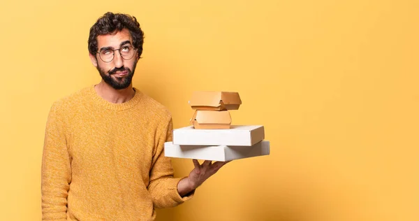 young crazy bearded man having take away fast food with a copy space