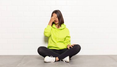 İspanyol kadın stresli, mutsuz ve hayal kırıklığına uğramış, alnına dokunuyor ve şiddetli baş ağrısı çekiyor.