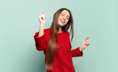 Genç, hoş, sıradan bir kadın gülümsüyor, kaygısız hissediyor, rahat ve mutlu, dans ediyor ve müzik dinliyor, bir partide eğleniyor.