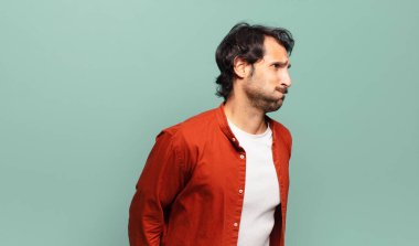 Genç, yakışıklı Hintli adam şapşal, çılgın, şaşkın bir ifadeyle, yanakları şişen, doldurulmuş, şişman ve yemekle dolu