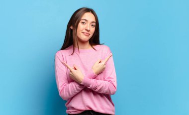 Şaşkın, kafası karışmış, güvensiz ve zıt yönlere şüpheyle bakan genç, hoş, sıradan bir kadın.