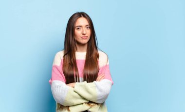 Genç, hoş, sıradan bir kadın hayal kırıklığına uğramış ve hayal kırıklığına uğramış, ciddi görünüyor, kızgın ve kollarını kavuşturmuş.