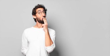 Genç, sakallı ve sigaralı bir adam. sigara içilmiyor.