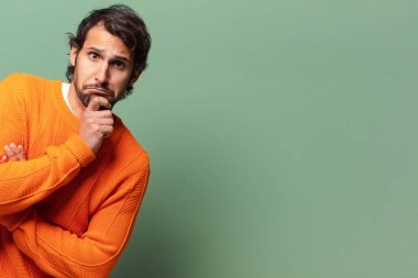 Genç, yakışıklı, etkileyici ve düşünceli Hintli bir adamın fotokopi alanı.