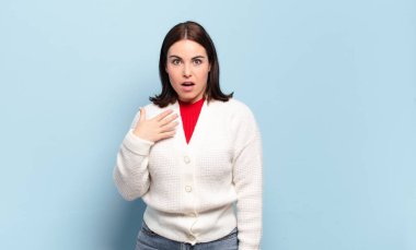 Genç ve hoş bir kadın şok olmuş, şaşırmış ve şaşırmış hissediyor, elleri göğsünde ve ağzı açık, kim olduğumu söylüyor, ben mi??