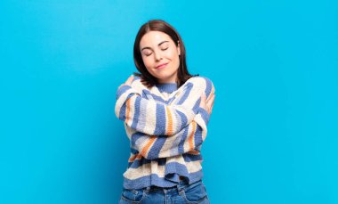 Genç, hoş, sıradan bir kadın aşık, gülümseyen, sarılan ve kendine sarılan, bekar, bencil ve bencil.