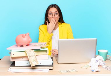 Masasında oturan iş kadını bir dizüstü bilgisayarla çalışıyor.