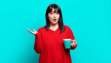 Artı boyut olarak güzel bir kadın ağzı açık ve şaşkın, şok olmuş ve hayretler içinde inanılmaz bir sürprizle