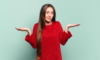 Genç, hoş, sıradan bir kadın şaşkın ve kafası karışık, şüpheci, farklı seçenekleri tartıyor ya da komik bir ifadeyle seçiyor.