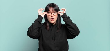 Ayrıca boyunda güzel bir kadın şaşkın, şaşkın ve şaşırmış, elinde şaşkın, inançsız bir bakışla gözlük tutuyor.