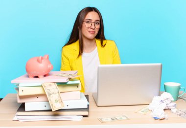 Masasında oturan iş kadını bir dizüstü bilgisayarla çalışıyor.