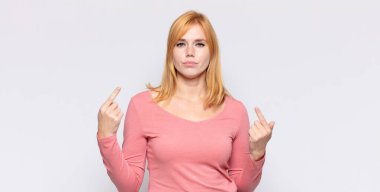 Kızıl saçlı, kötü tavırlı, gururlu ve agresif görünen, yukarıyı gösteren ya da ellerinle alay eden güzel bir kadın.