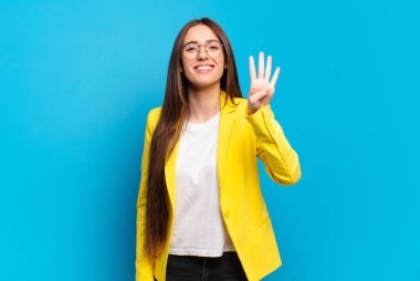 Genç, güzel bir kadın gülümsüyor ve arkadaş canlısı görünüyor. Dört ya da dört numarayı gösteriyor. Elleri önde, geri sayıyor.