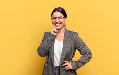 Genç ve güzel bir kadın mutlu bir şekilde gülümsüyor ve hayal kuruyor ya da şüphe ediyor.