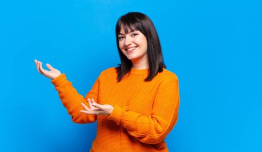 Artı boyut olarak güzel bir kadın gururla ve güvenle gülümsüyor, mutlu ve tatmin olmuş hissediyor ve fotokopi alanında bir konsept gösteriyor.