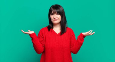 Artı boyut olarak güzel bir kadın kafası karışmış ve stresli görünüyor, farklı seçenekler arasında merak ediyor, kararsız hissediyor.