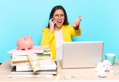 Masasında oturan iş kadını bir dizüstü bilgisayarla çalışıyor.