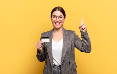 Genç ve güzel bir kadın bir fikri fark ettikten sonra mutlu ve heyecanlı bir dahi gibi hissediyor. Neşeli bir şekilde parmağını kaldırıyor.!