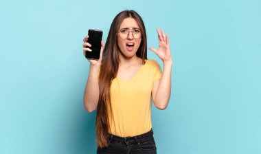 Genç ve güzel bir kadın ellerini havaya kaldırarak bağırıyor. Öfkeli, sinirli, stresli ve üzgün.