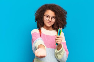 Şirin afro bir genç, güler yüzlü, kendine güvenen, olumlu bakışlı, bir nesne ya da konsept sunan ve gösteren. öğrenci konsepti