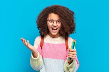 Oldukça afro bir genç mutlu, şaşırmış ve neşeli, pozitif bir tavırla gülümsüyor, bir çözüm ya da fikri fark ediyor. öğrenci konsepti