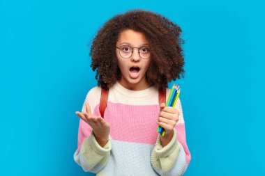 Oldukça afro bir genç aşırı şaşkın ve şaşırmış, endişeli ve panik içinde, stresli ve dehşete düşmüş bir bakışla. öğrenci konsepti