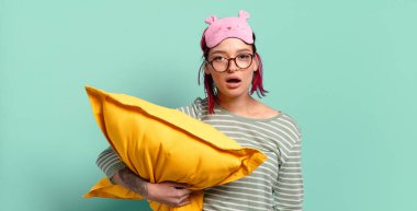 Genç ve çekici kızıl saçlı kadın şok olmuş ya da şaşırmış görünüyor, ağzı açık bir şekilde 