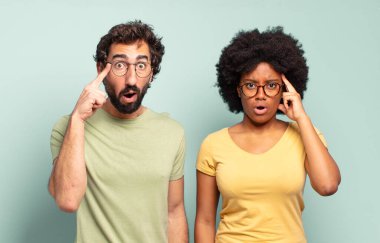 Şaşırmış, ağzı açık, şok olmuş, yeni bir düşünce, fikir ya da konsept keşfeden çok ırklı iki arkadaş.