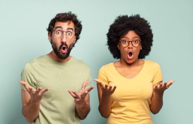 Son derece şok olmuş, şaşırmış, endişeli ve paniklemiş hisseden iki arkadaş, stresli ve dehşete kapılmış bir bakışla